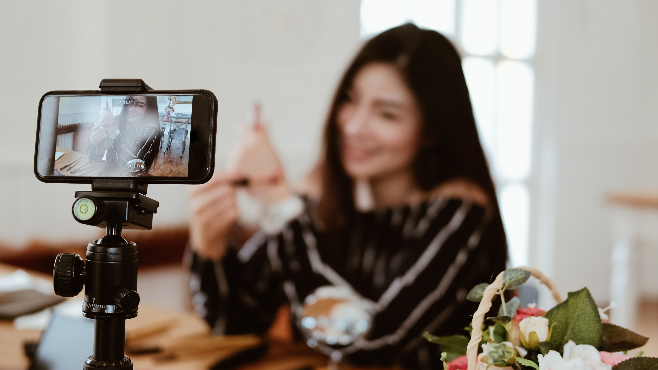 Content creator filming a product video on a smartphone to build brand awareness for a startup.